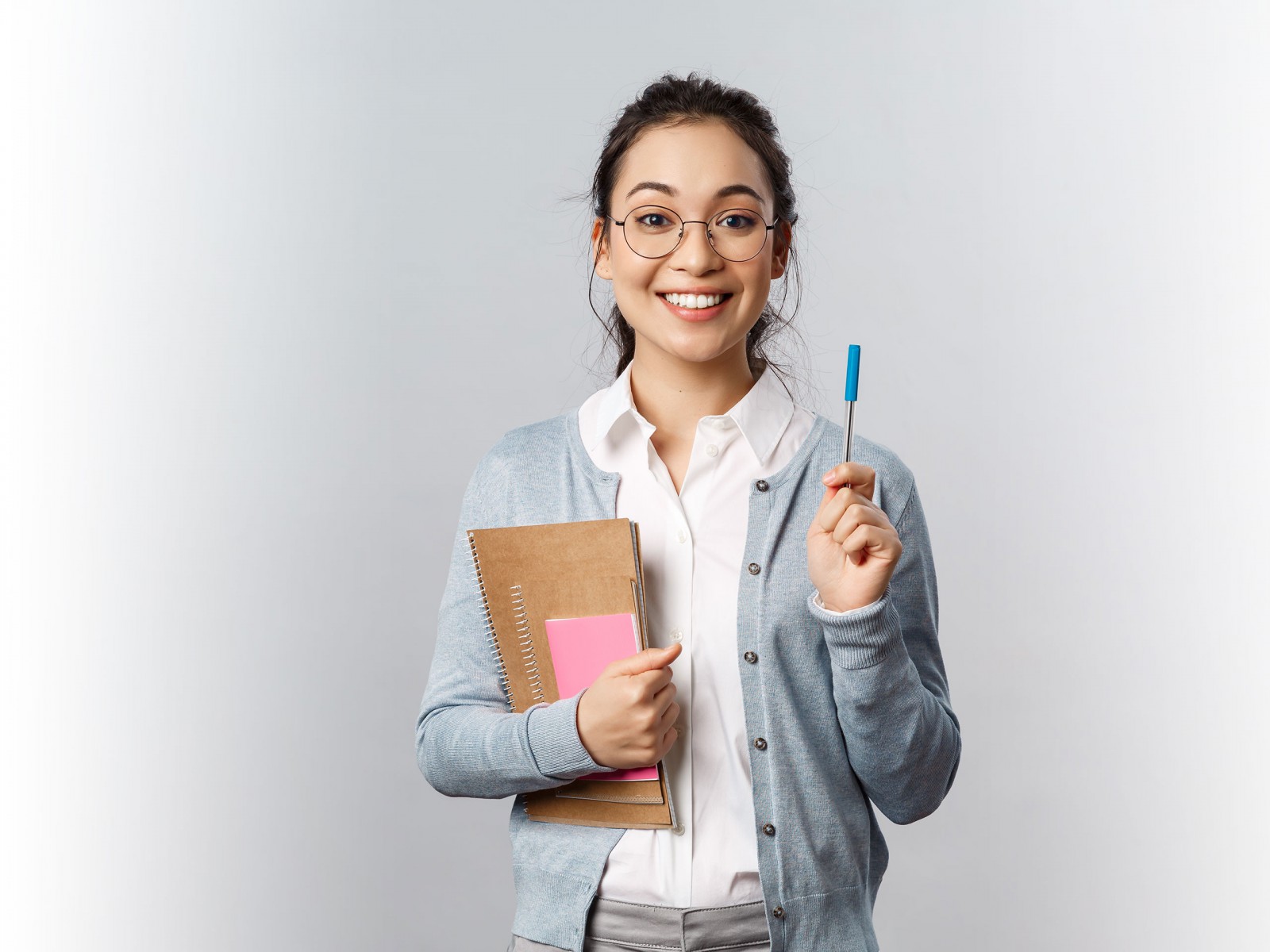 Student smiling holding pen