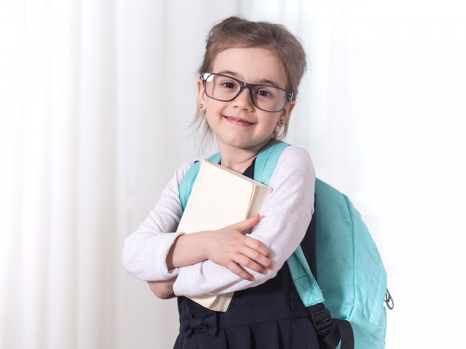 Young girl with backpack and books